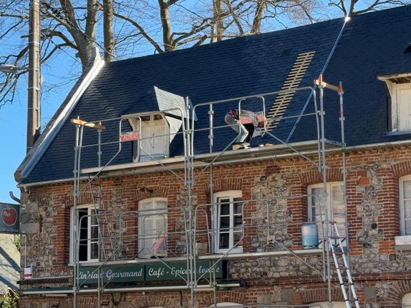 Versant en cours de couverture en ardoise, échafaudage monté en façade